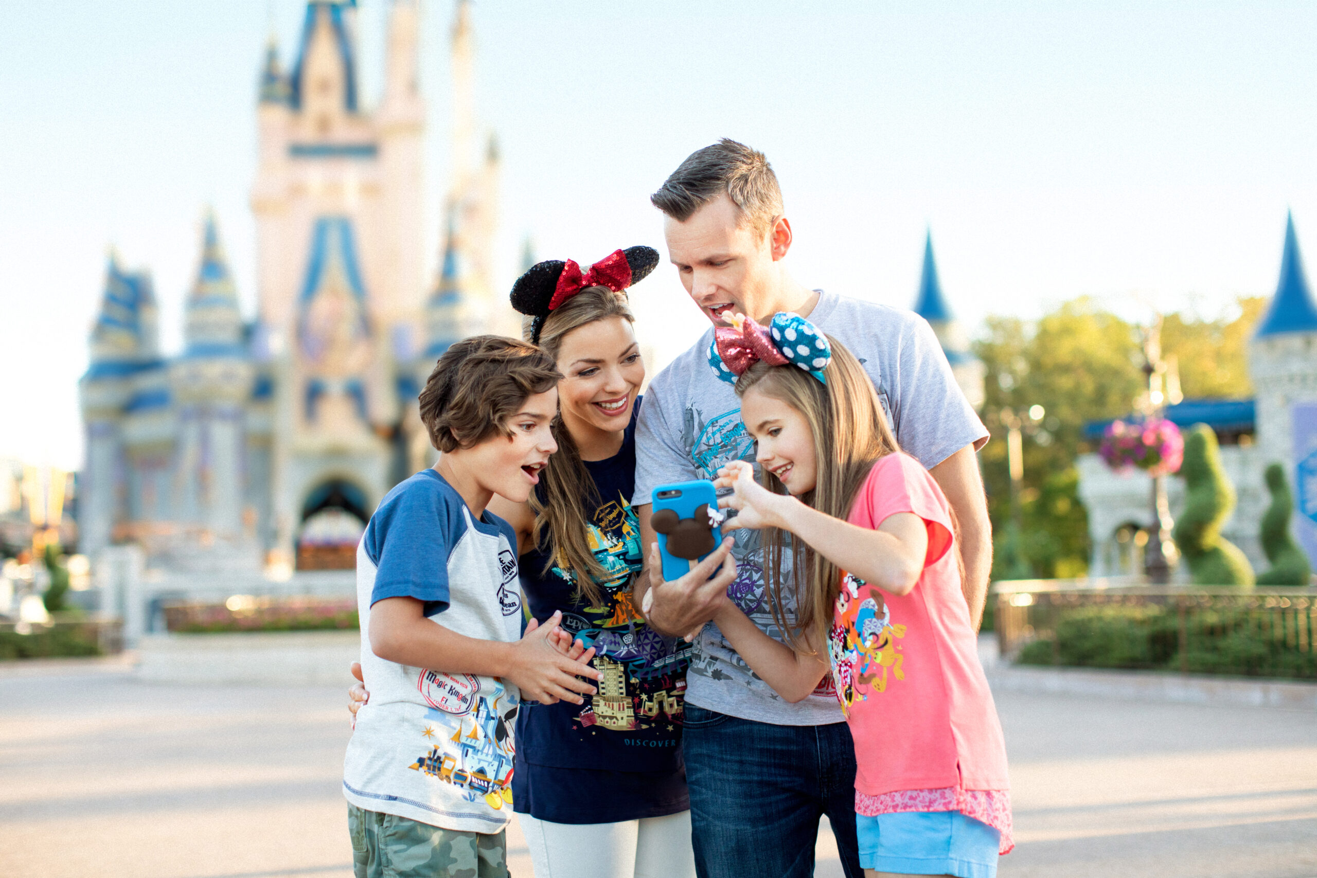Family using Disney Genie on a mobile phone at Walt Disney World