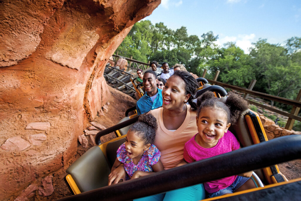 Mom and daughters riding Big Thunder Mountain Railroad at Magic Kingdom. Using Disney Genie+ to save time waiting in line for this and 40+ Attractions
